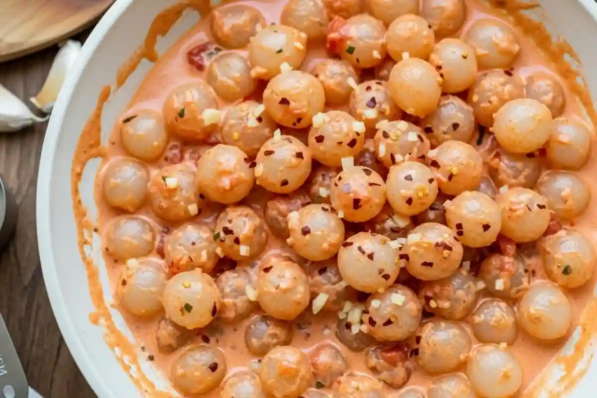 Pearl onions in creamy vodka tomato sauce.